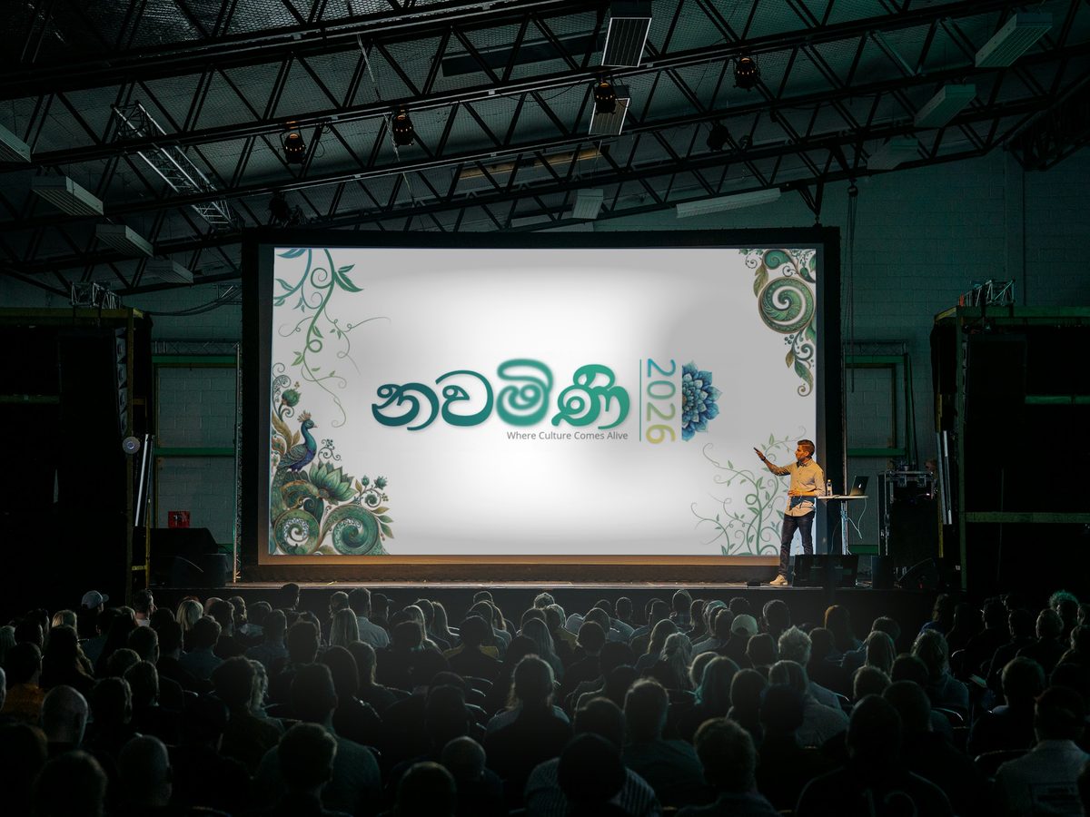 The Nawamini 2026 title slide on a large stage screen in a full hall, with a presenter on stage