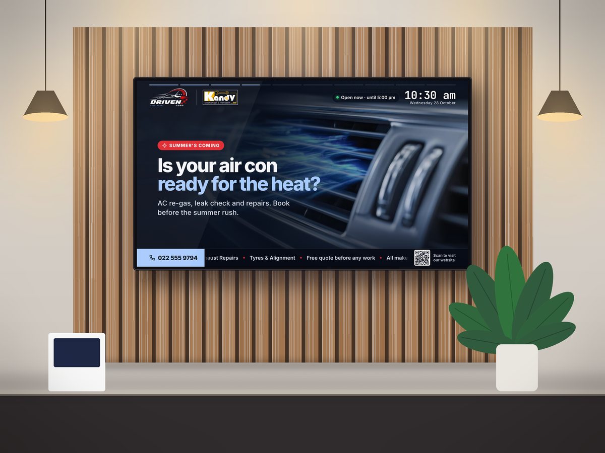 The Driven Auto Works air-con promotion slide on a wall-mounted TV with live clock, opening hours and QR code